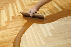 24527478 - varnishing of oak parquet floor, workers hand and tool